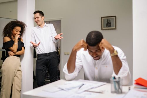 man being laughed at by co-workers