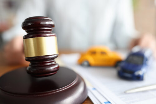 Judge holding hammer near toy cars closeup. Selling car at auction concept